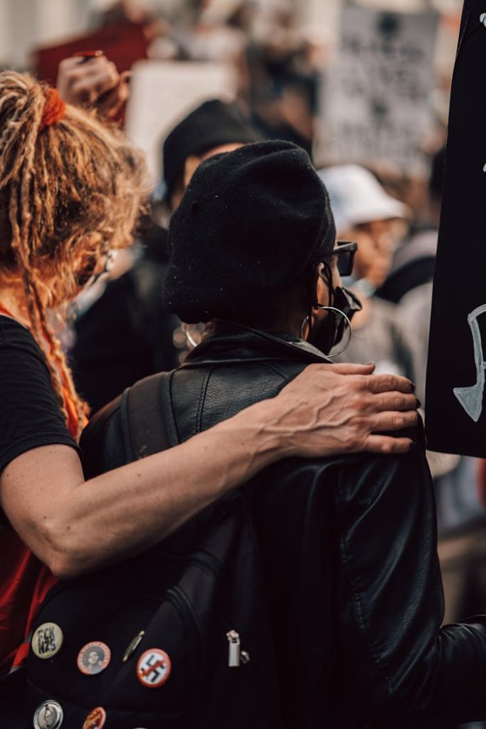 Two individuals embrace during a peaceful protest for equality and justice.